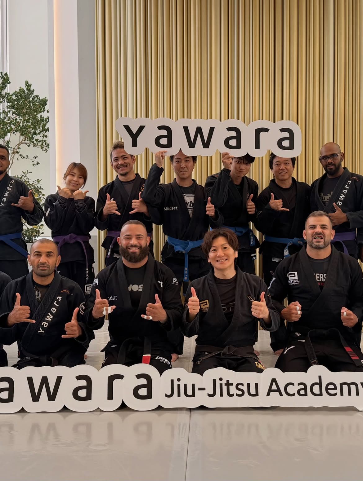 Uriel Meneses em foto de grupo com praticantes japoneses de jiu-jitsu em uma academia de Tóquio